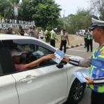 Petugas Satlantas Polresta Tangerang membagikan brosur imbauan tertib berlalu lintas kepada pengendara di kawasan Puspemkab Tangerang.