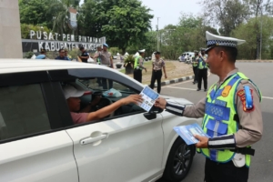 Petugas Satlantas Polresta Tangerang membagikan brosur imbauan tertib berlalu lintas kepada pengendara di kawasan Puspemkab Tangerang.