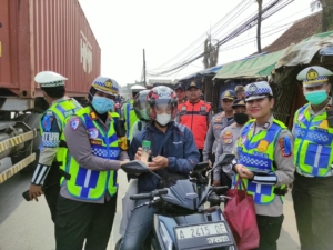 Petugas Satlantas Polresta Tangerang memberikan apresiasi kepada pengendara sepeda motor yang tertib dalam Operasi Patuh Maung 2026 di Balaraja.